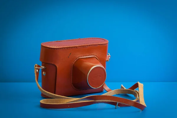 Mavi arka plan üzerinde kahverengi deri bir çanta Vintage kamera