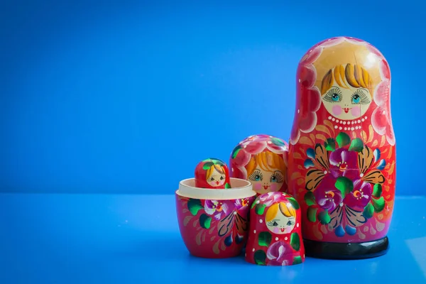 mavi bir arka plan üzerinde eski ahşap Rus yuvalama bebek, Rusya sembolü, kırmızı, metin için kopya alanı ile