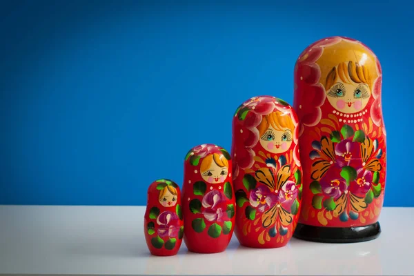 old wooden Russian nesting dolls on a blue background, a symbol of Russia, red, with copy space for text