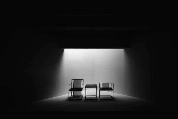 Duas cadeiras dramáticas pretas e brancas que sentam a decisão da reunião Importante junto holofotes pequenos da tabela vazio ninguém — Fotografia de Stock
