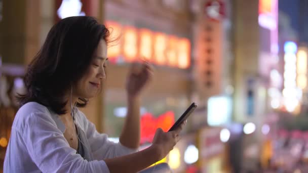 Junge asiatische Frau mit Telefon in der Straße — Stockvideo