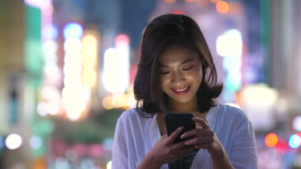 Junge asiatische Frau mit Telefon in der Straße — Stockvideo
