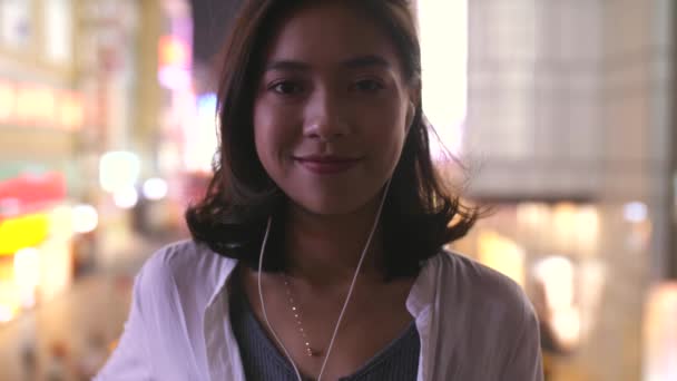 Красивая молодая азиатка улыбается в замедленной съемке — стоковое видео