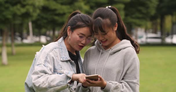 Deux asiatique collège fille à l'aide de téléphone mobile dans campus — Video