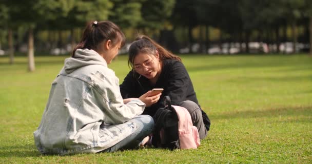 Dos asiático colegio chica usando móvil teléfono en campus — Vídeos de Stock