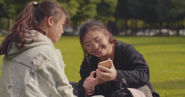 Dos asiático colegio chica usando móvil teléfono en campus — Vídeo de stock