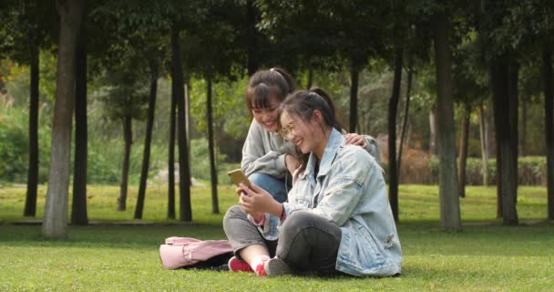 Zwei asiatische College-Mädchen mit Handy in Campus — Stockvideo