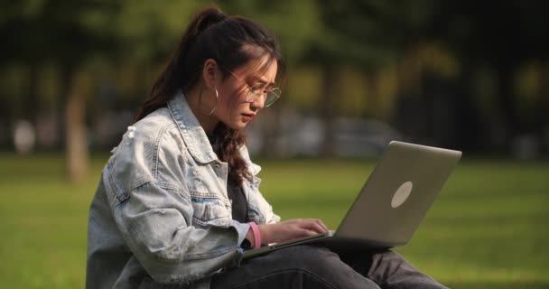 Una chica universitaria usando laptop en el campus — Vídeo de stock