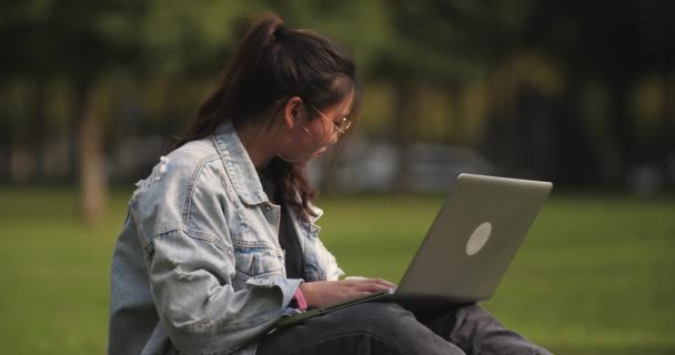 Una chica universitaria usando laptop en el campus — Vídeo de stock