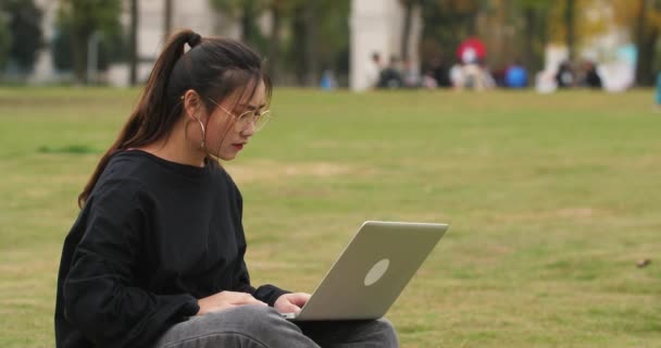 Asiatique collège fille en utilisant ordinateur portable dans la pelouse sur le campus — Video