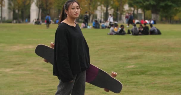 Asiatiska kvinnliga College studentporträtt med skateboard — Stockvideo