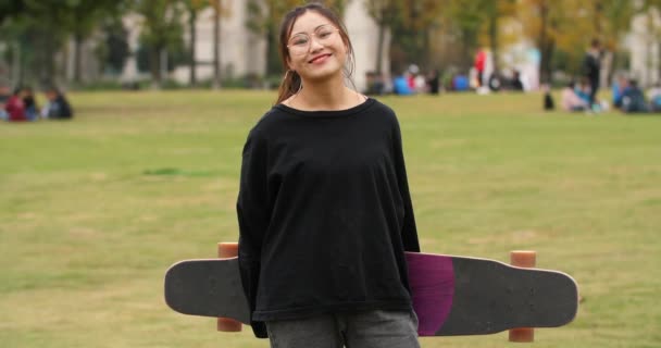 Азиатский студенческий портрет со скейтбордом — стоковое видео