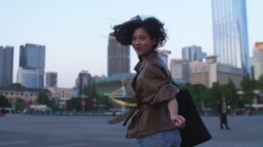 Pretty genç asyalı kadın akşam şehirde çalışan, 4k