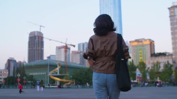 Hübsche junge asiatische Frau läuft in der Stadt am Abend, 4k — Stockvideo