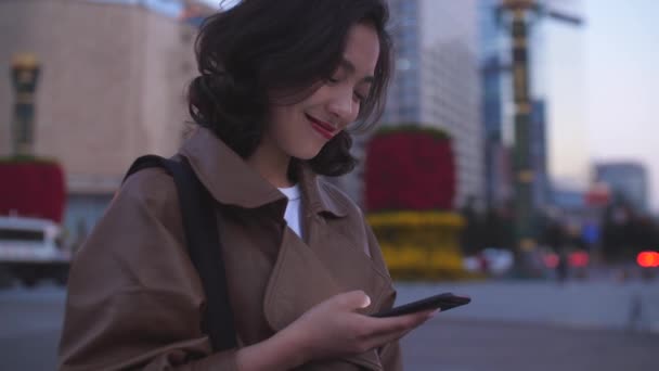 Gece şehir caddesinde cep telefonu kullanarak güzel genç asyalı kadın, 4k — Stok video
