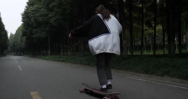 Young asian girl skateboarding on the road slow motion — ストック動画