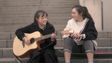 Gençler birlikte açık havada müzik çalıyor