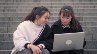 Kampüste dizüstü bilgisayar kullanan iki üniversiteli kız