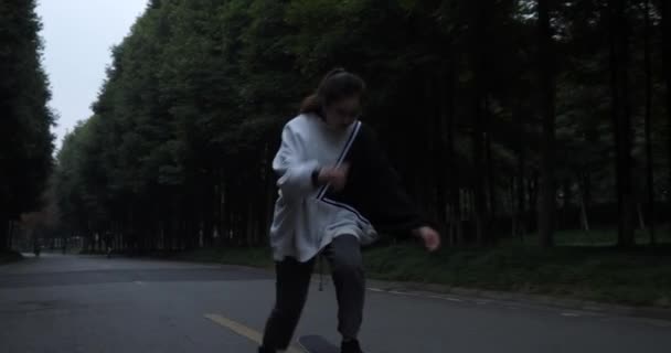 Mladá Asijská dívka skateboardingu na cestě — Stock video