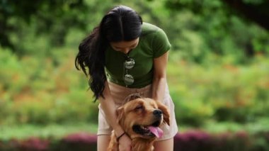 Uzun saçlı, yaz parkında köpekli Asyalı bir kadın.