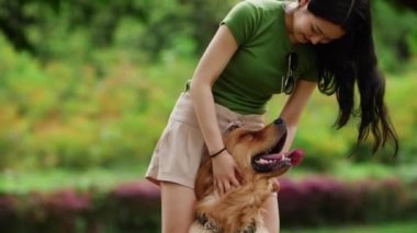 Uzun saçlı, yaz parkında köpekli Asyalı bir kadın.