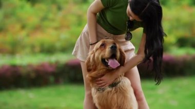 Uzun saçlı Asyalı kadın köpekle birlikte yaz parkında.