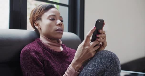 Αφρικανική γυναίκα κοιτάζοντας το κινητό τηλέφωνο αισθάνονται ανακούφιση — Αρχείο Βίντεο