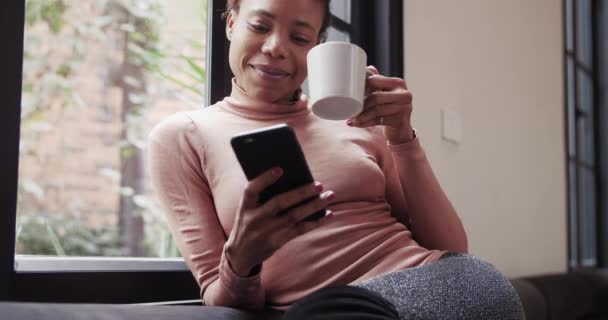 Mujer africana feliz usando el móvil en casa — Vídeos de Stock