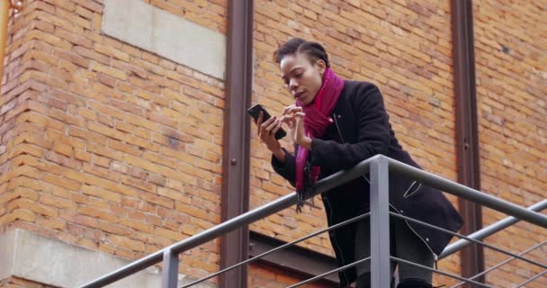 Feliz joven africana escribiendo en el teléfono móvil — Vídeos de Stock