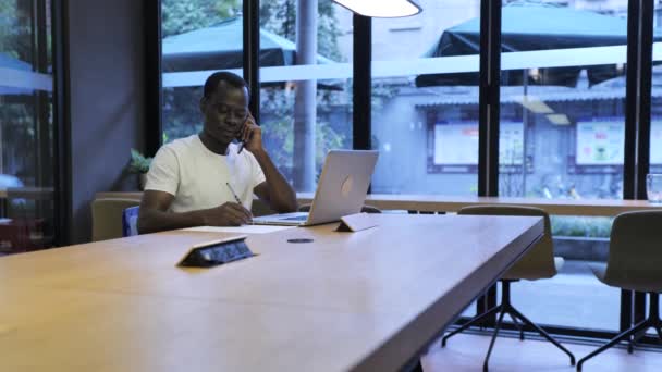 Afrikaanse zakenman in gesprek aan de telefoon in het kantoor — Stockvideo