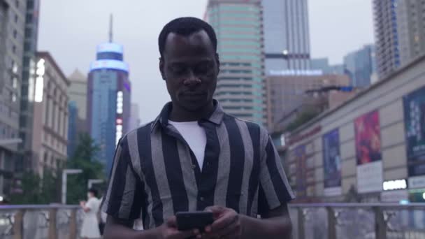 Hombre negro en la calle usando teléfono móvil — Vídeo de stock