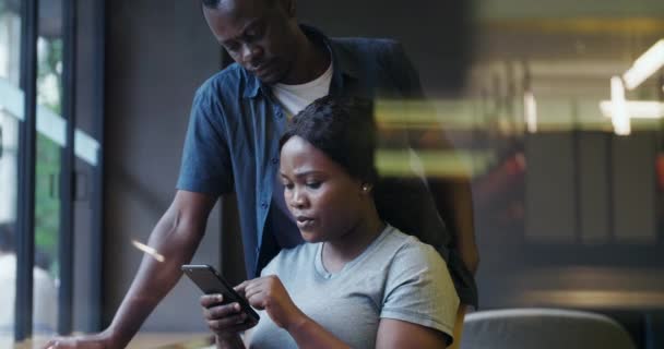 Serieus zwart paar op zoek naar mobiele telefoon — Stockvideo