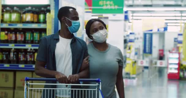 Африканська пара за покупками в супермаркеті з маскою. — стокове відео