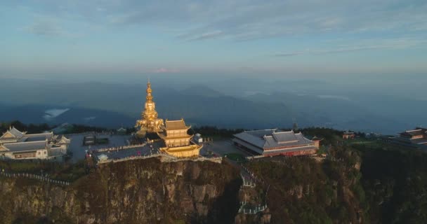 Golden Buddha statue in the mountain peak by the cliff — Stock Video