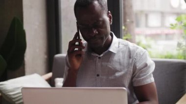 Siyah iş adamı dizüstü bilgisayarla çalışıyor