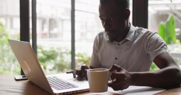 Zwarte zakenman werkt aan laptop — Stockvideo