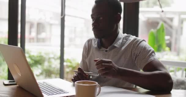 Man werkt met laptop drinkcafé — Stockvideo