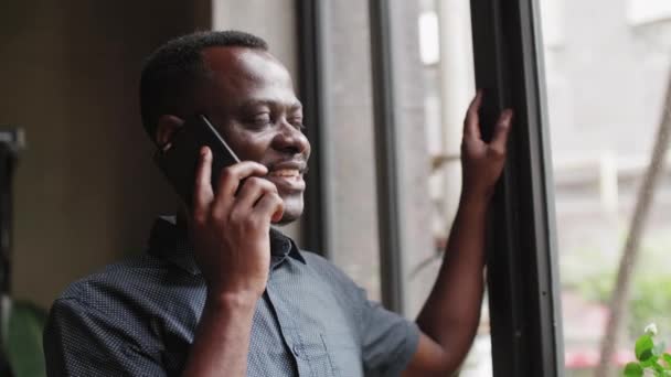 Glad svart ung man pratar i telefon — Stockvideo
