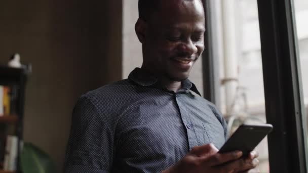 Homem negro feliz olhando para o telefone — Vídeo de Stock