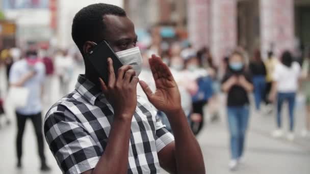 Homem negro falando ao telefone na rua com máscara — Vídeo de Stock