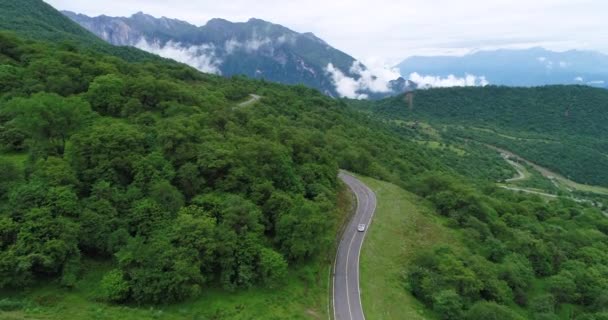 Drone following view of car driving on winding mountain road — Stock Video