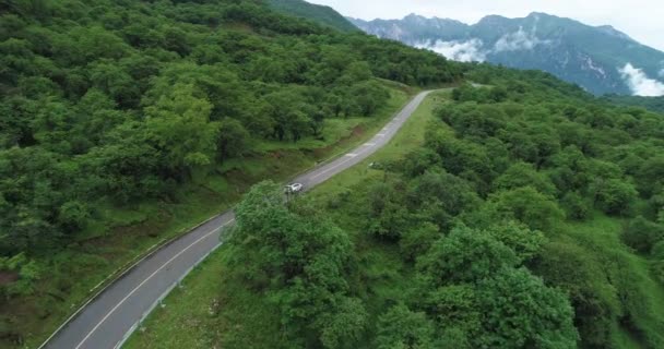 Проезд по извилистой дороге в горном ландшафте — стоковое видео