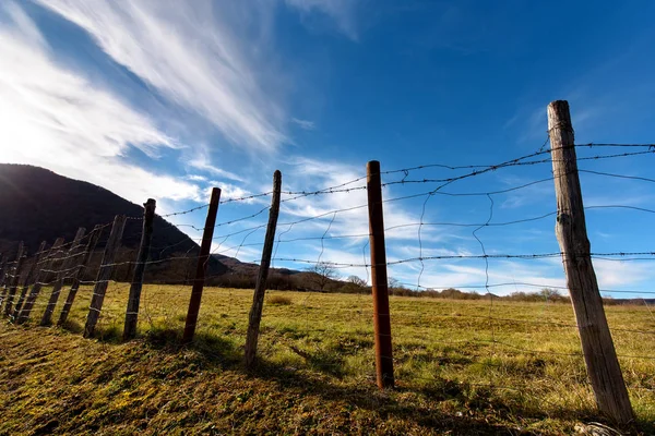 Ostnatým drátěným plotem na venkově Stock Fotografie