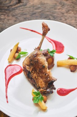 ördek confit karamelize elma ve patates beyaz tabakta bacak