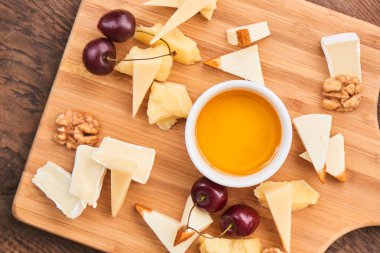 fincan zeytin yağı ve kiraz ahşap tahta üzerinde mozzarella ve camembert peynirler ile parmesan kümesiyle