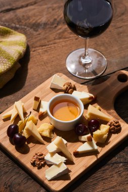 Ahşap tahta üzerinde kırmızı şarap ile mozzarella ve camembert peynirler ile parmesan kümesi