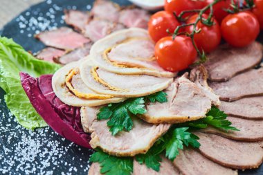 Biftek pişmiş jambon ve tavuk rulo sığır dilini ve taş tahtaya hizmet domates ile