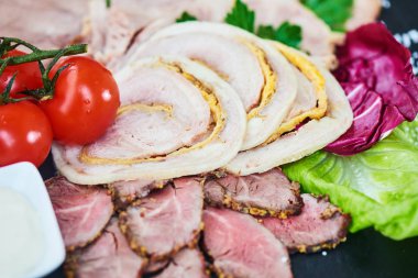 Biftek pişmiş jambon ve tavuk rulo sığır dilini ve taş tahtaya hizmet domates ile