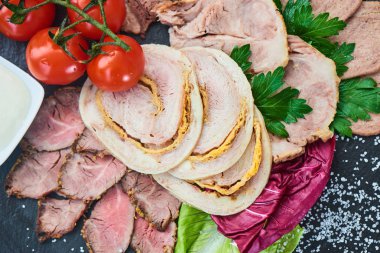 Biftek pişmiş jambon ve tavuk rulo sığır dilini ve taş tahtaya hizmet domates ile