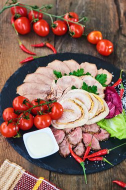 Biftek pişmiş jambon ve tavuk rulo sığır dilini ve taş tahtaya hizmet domates ile